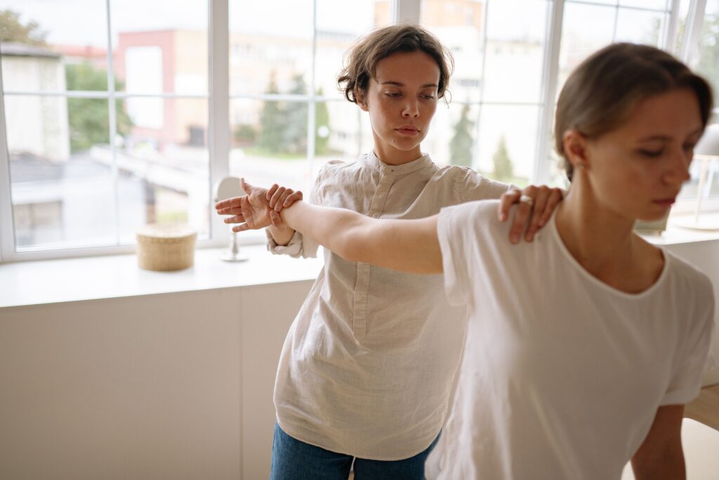 Physiotherapist demonstrating arm mobility exercise at a physiotherapy center in Tohana