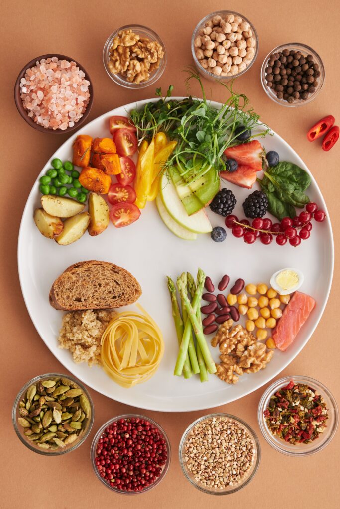 A vibrant assortment of healthy foods on a plate, showcasing a balanced diet with fruits, vegetables, nuts, and grains.